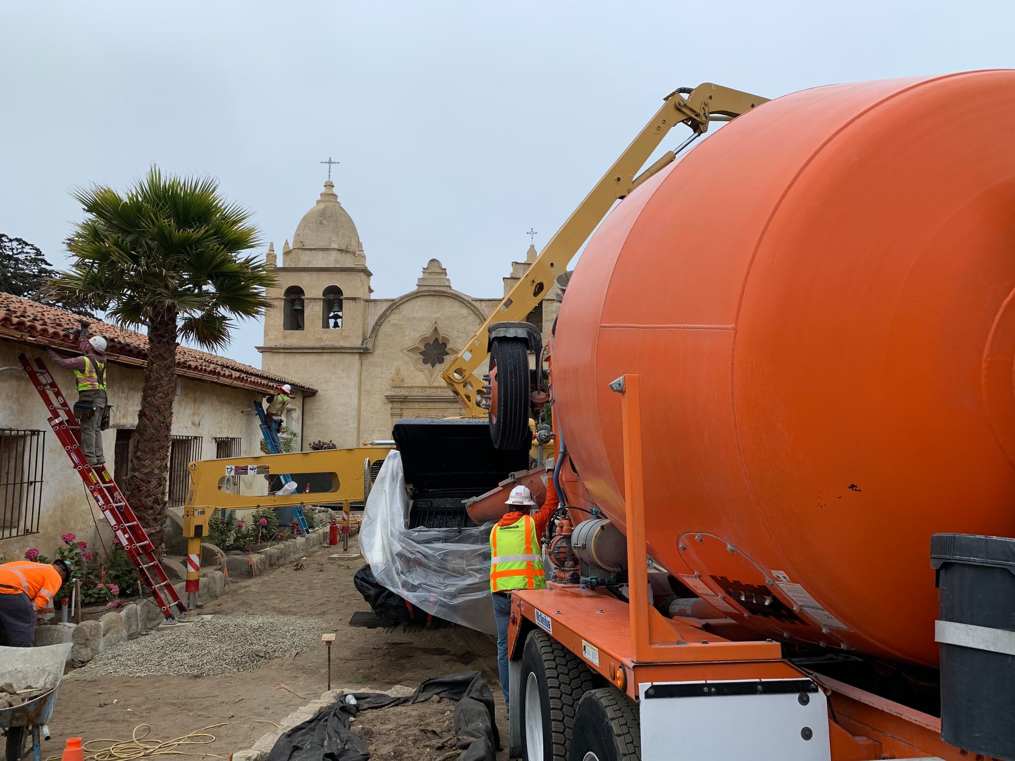 Orange ready-mix truck pouring concrete at a job site