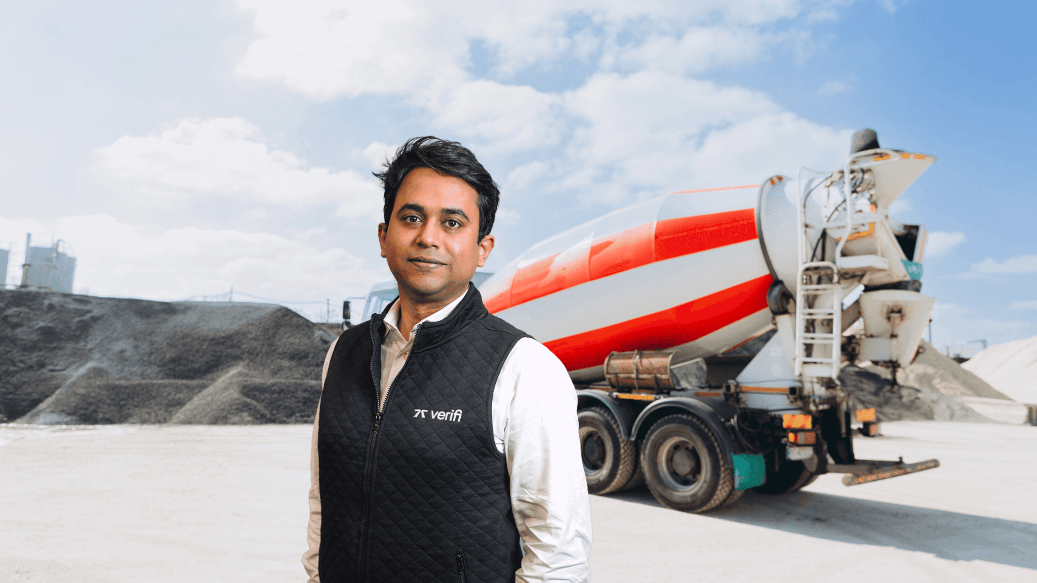 Sid Singh standing in front of a ready-mix concrete truck.