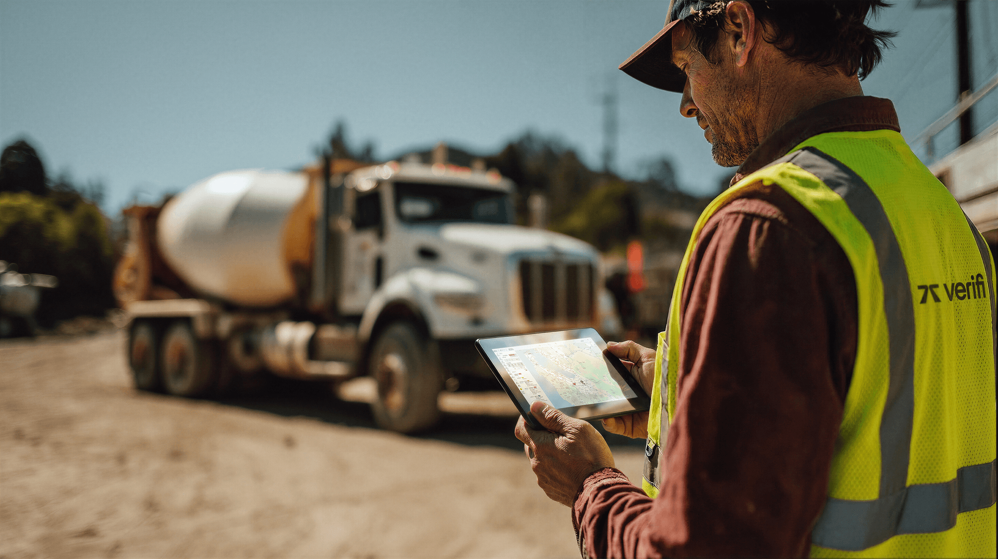 Verifi employee looking at a tablet showing a realtime map at a work site